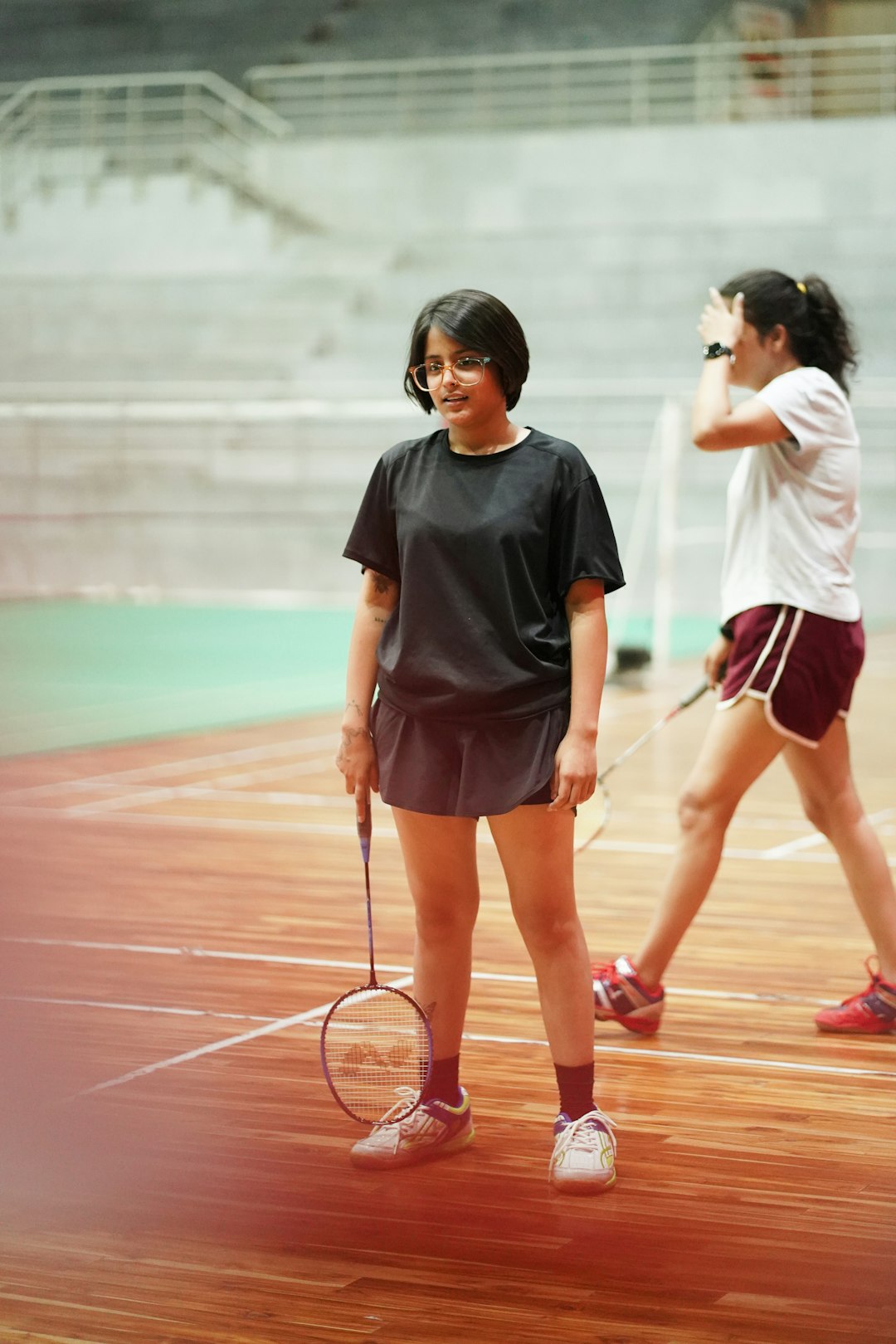 two-young-women-standing-on-a-tennis-court-holding-racquets-srcropdp-dy